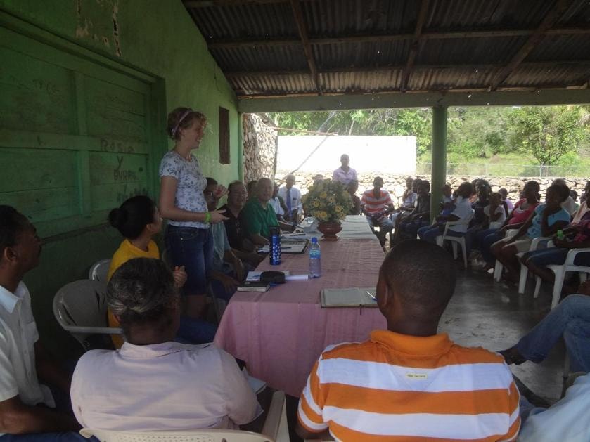 EWB volunteer presenting to Carlos Pinto community members at an outdoor meeting